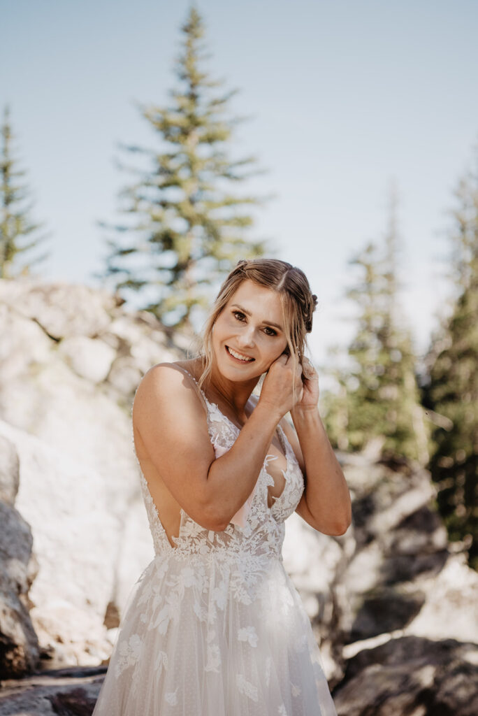 Jackson Wy photographer captures bride putting on earrings after Grand Teton hike to her elopement location