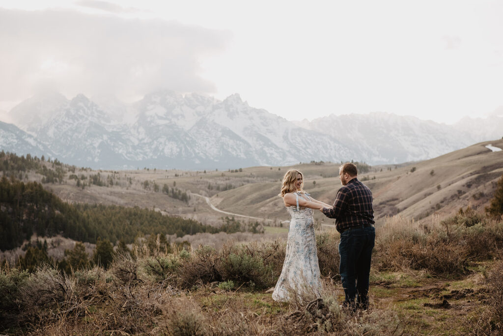 Jackson Wy photographer captures couple dancing together in grassy area in Jackson Hole