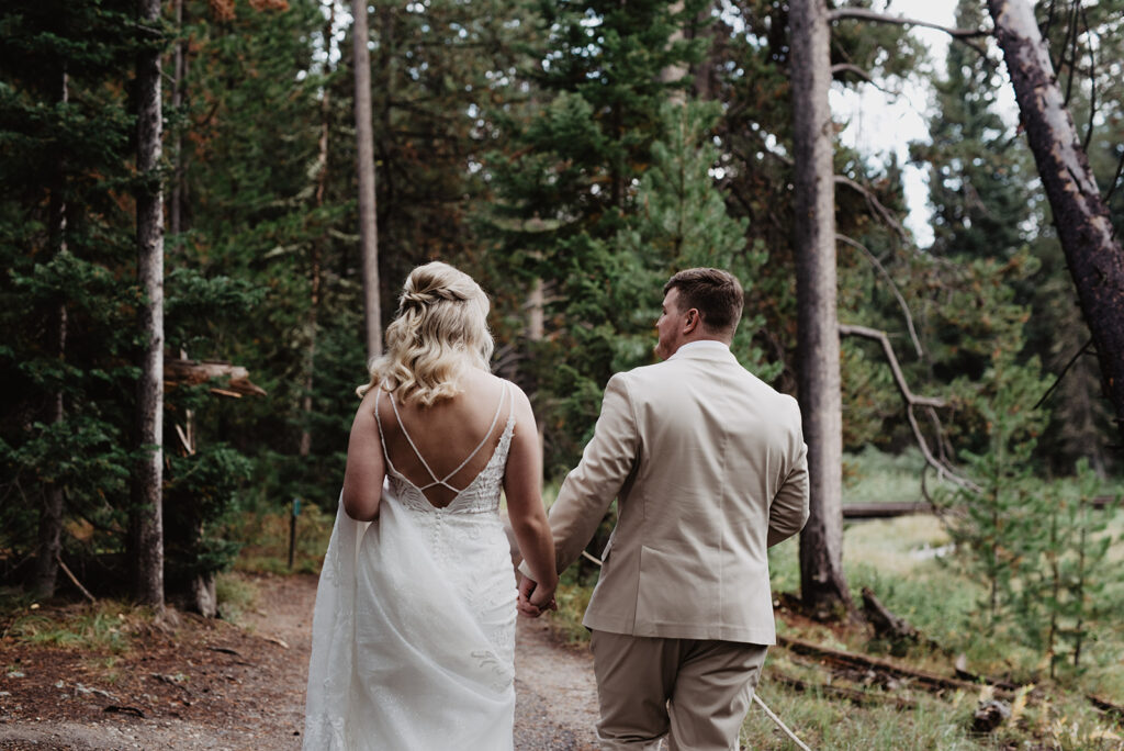 Jackson Hole Wedding Photographer captures groom holding bride's hand 