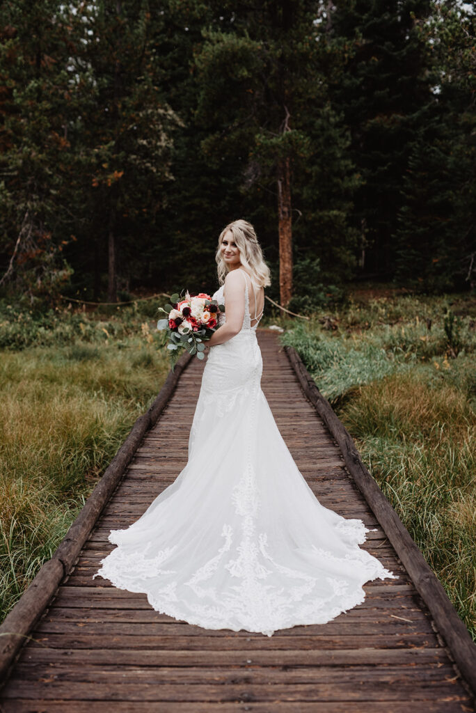 Jackson Hole Wedding Photographer captures bride looking over shoulder wearing wedding dress
