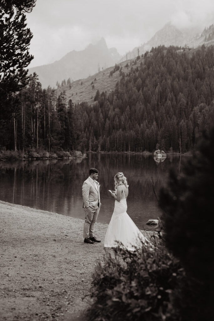 Jackson Hole Wedding Photographer captures black and white portrait of bride reading vows to groom