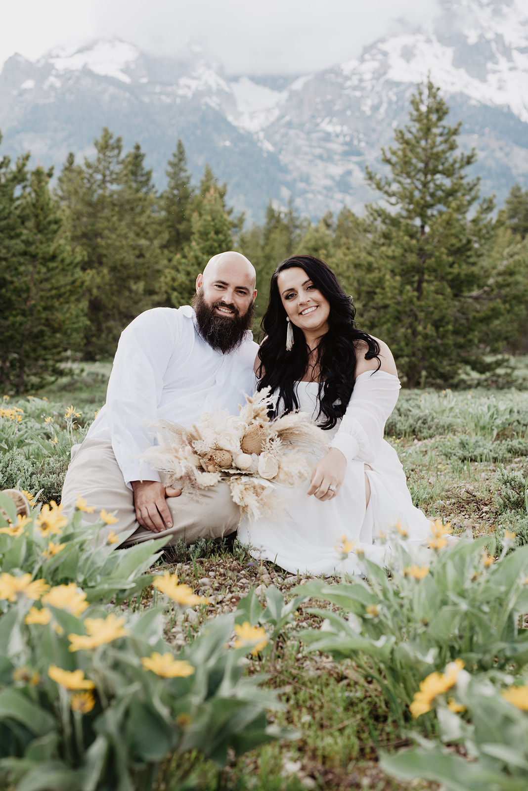 Wyoming Elopement Photographer captures couple sitting in flowers after elopement