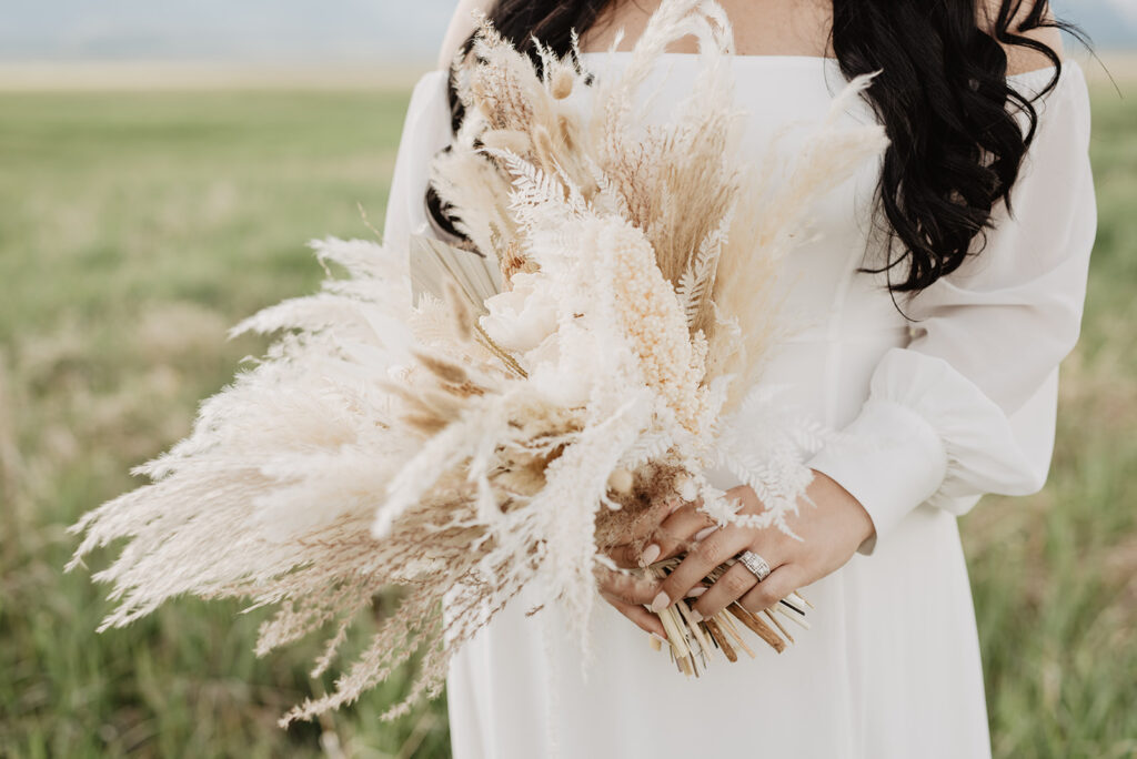 Wyoming Elopement Photographer captures close up of bridal bouquet with pampas grass