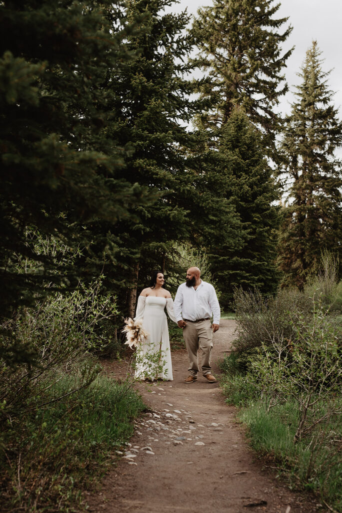 Wyoming Elopement Photographer captures couple walking through forest