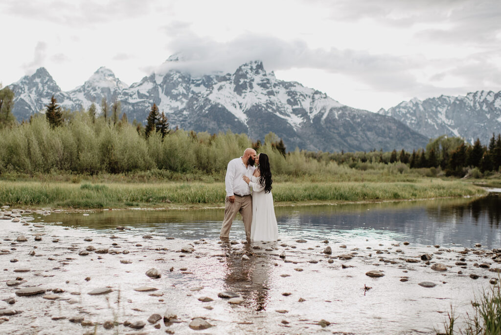 Wyoming Elopement Photographer captures couple wading in water during engagement photos