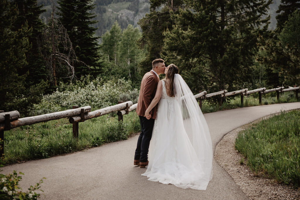 Grand Teton Wedding Photographer captures bride and groom kissing as they walk