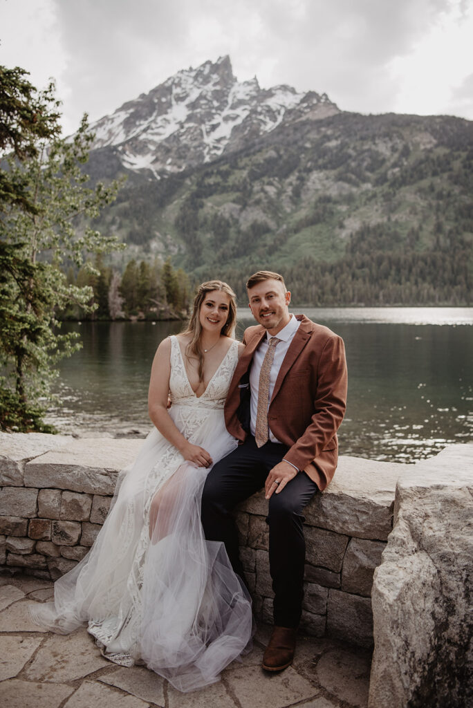 Grand Teton Wedding Photographer captures bride and groom sitting on log together