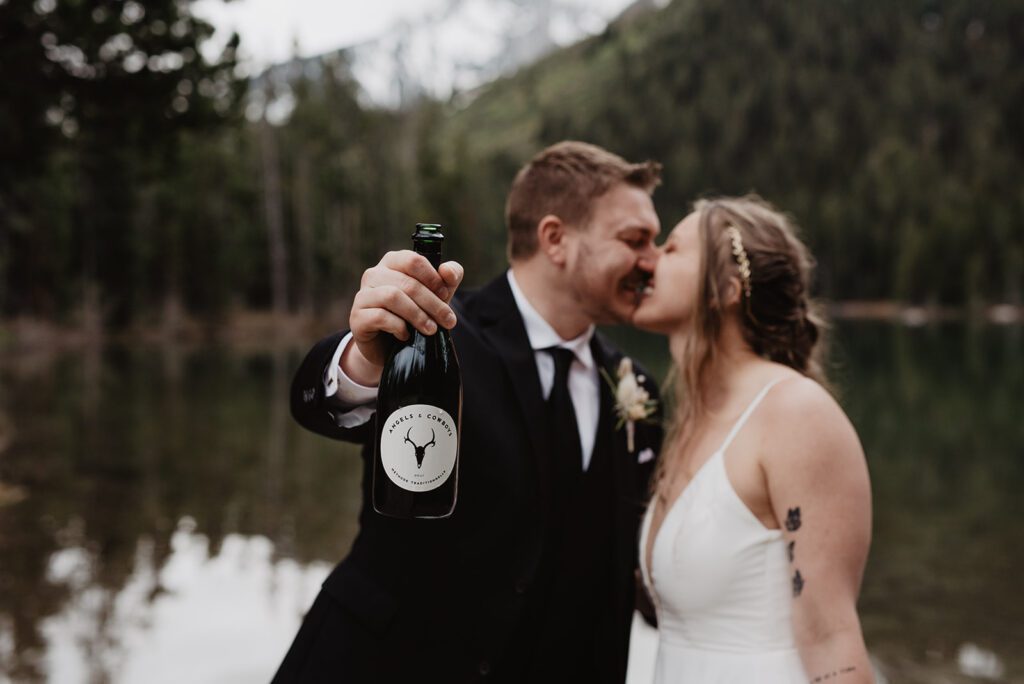 Jackson Hole Elopement Photographer captures bride and groom celebrating with champagne