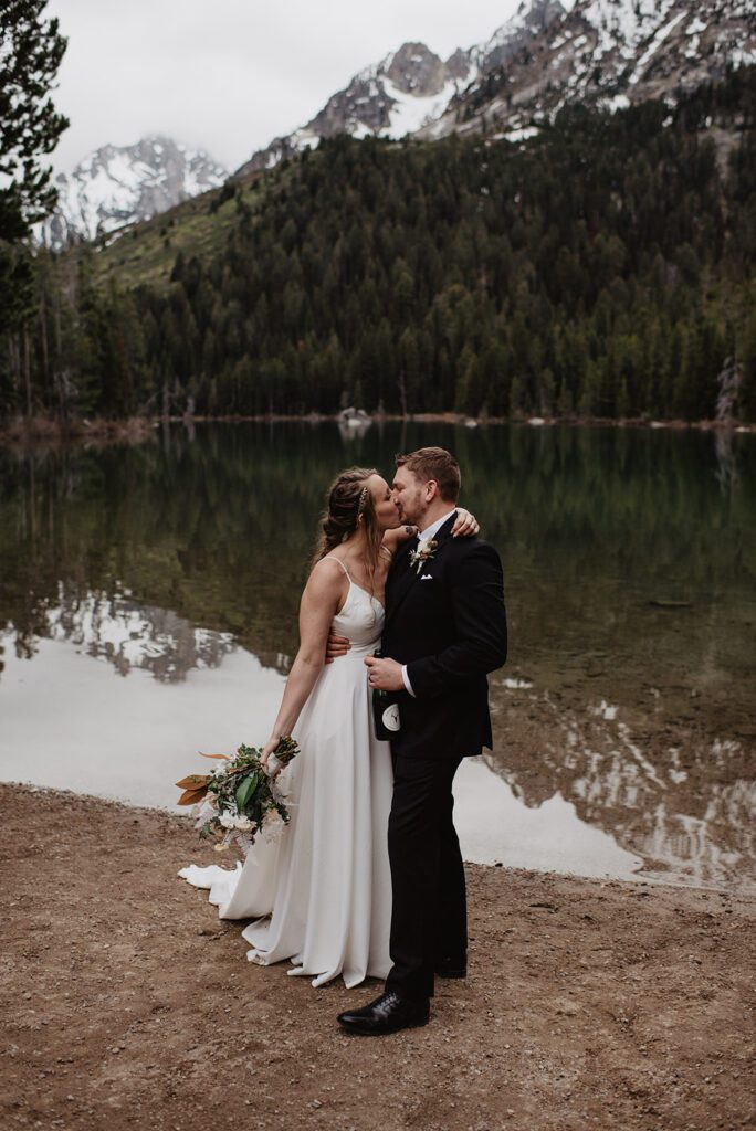 Jackson Hole Elopement Photographer captures bride and groom embracing by lake