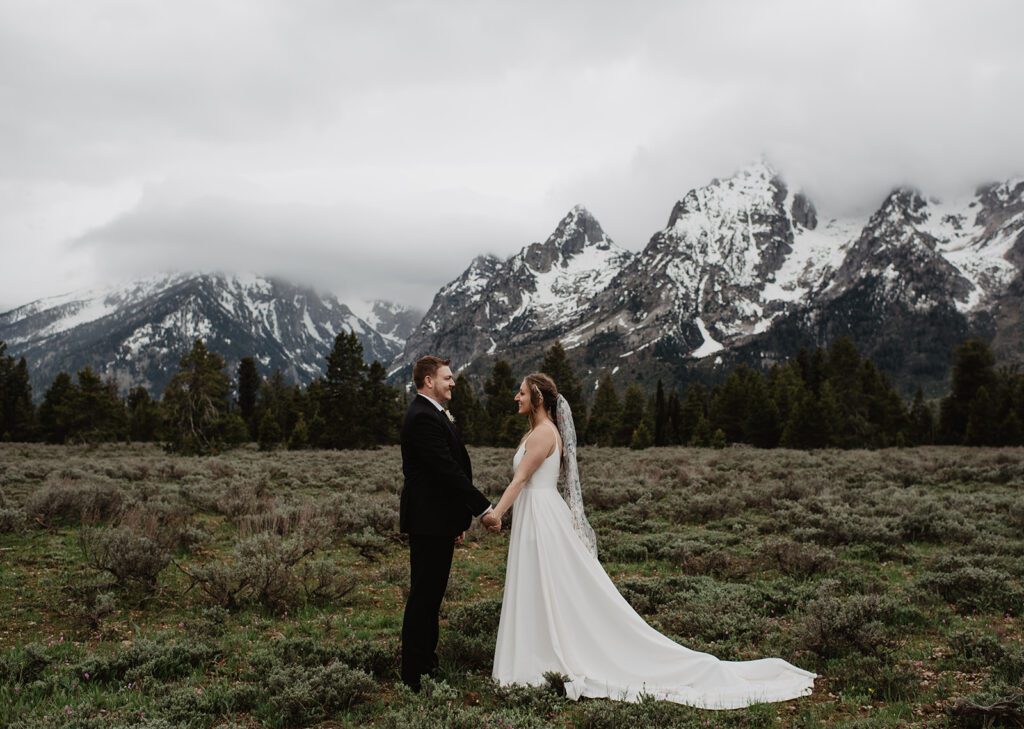 Jackson Hole Elopement Photographer captures bride and groom holding hands in front of mountains