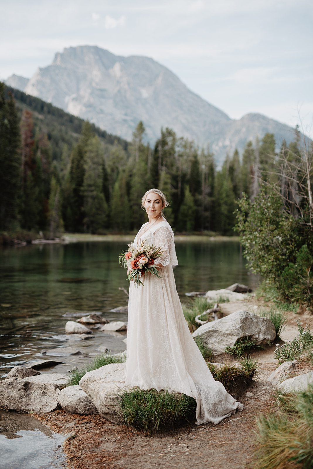 Jackson Hole Elopement Photographer captures bride holding bouquet standing on boulder
