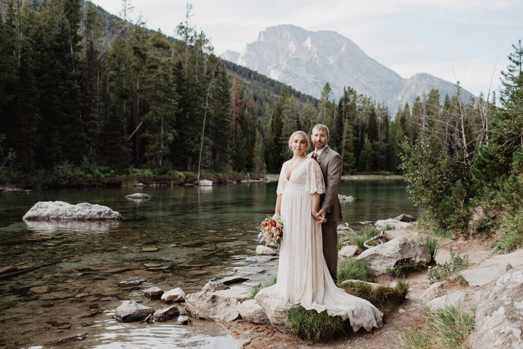 Jackson Hole Elopement Photographer captures bride and groom standing together on boulder