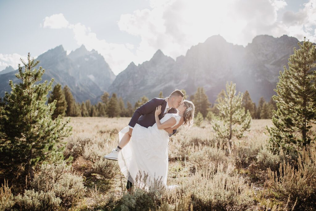 Jackson Hole Photographer captures groom dip kissing bride in front of Tetons
