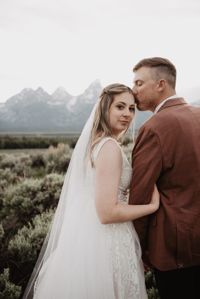 Jackson Hole elopement photographer captures groom kissing bride's forehead